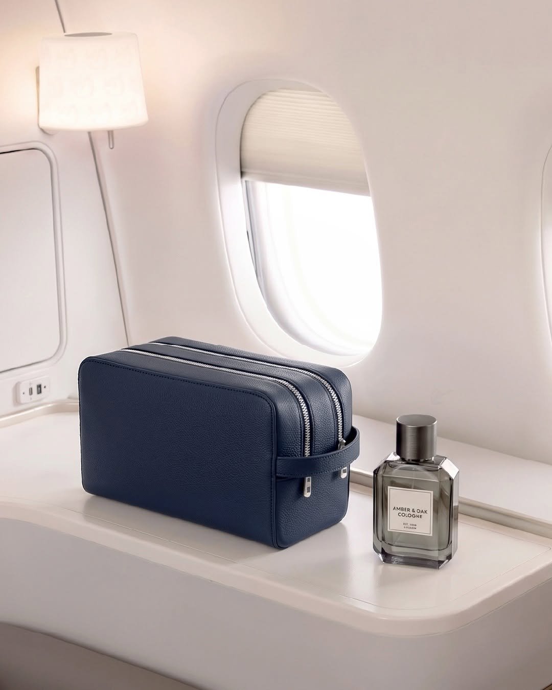 Navy leather dopp kit on airplane tray table