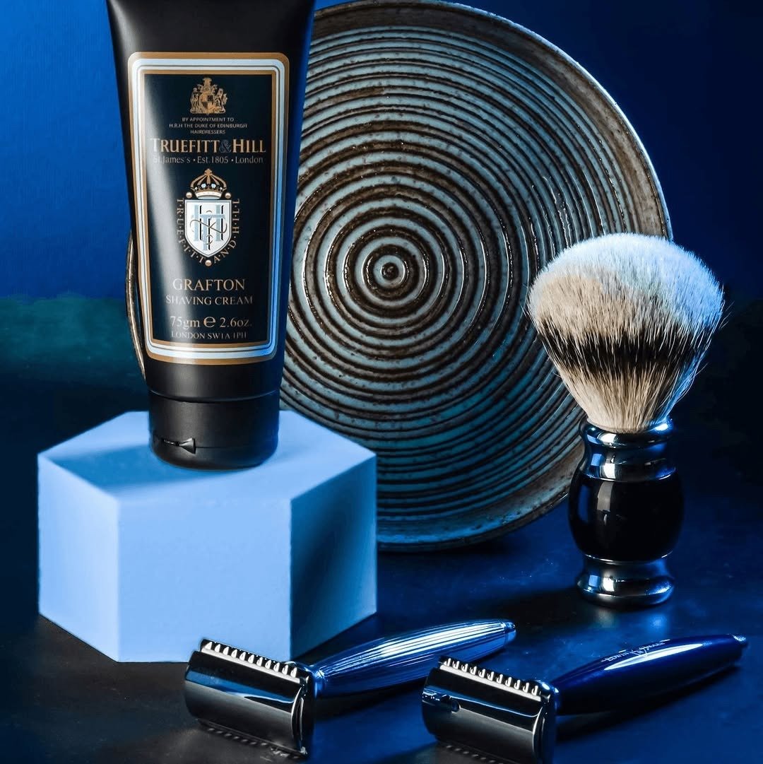 Shaving cream, brush and safety razors on dark blue
