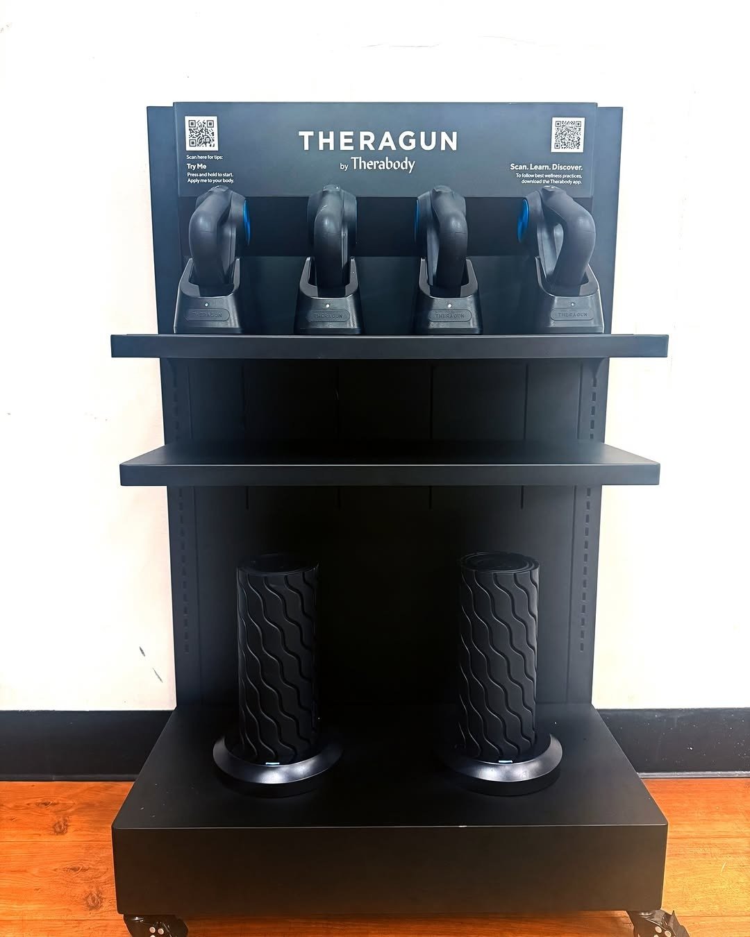 Theragun massage guns on a recovery station stand
