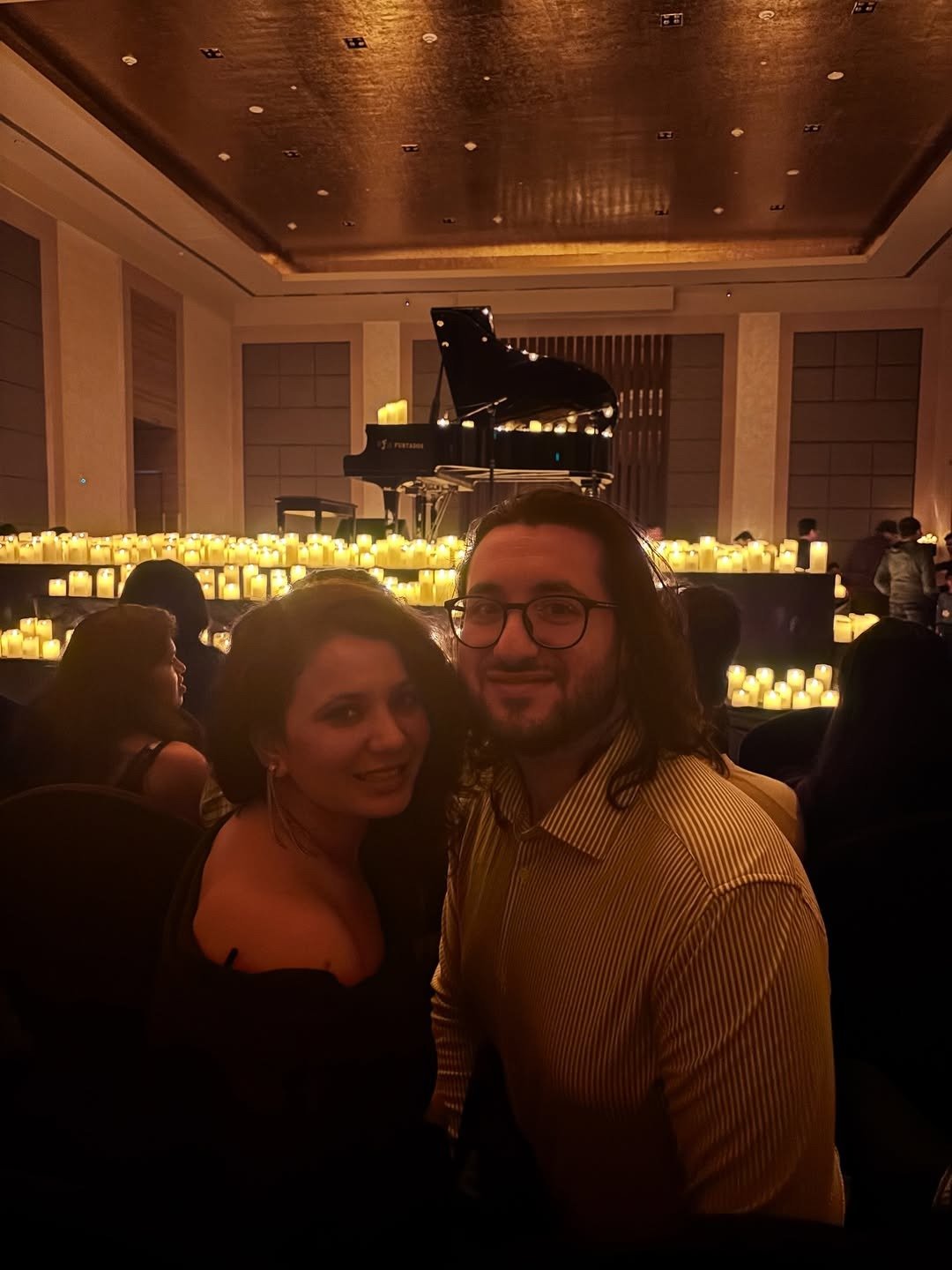 Couple seated at a candlelight concert with a piano