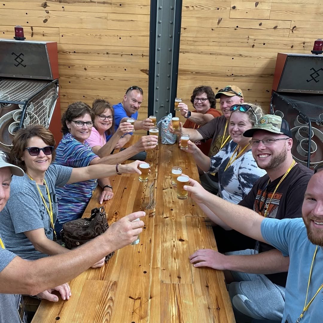 Group toasting with beer tasting glasses at brewery