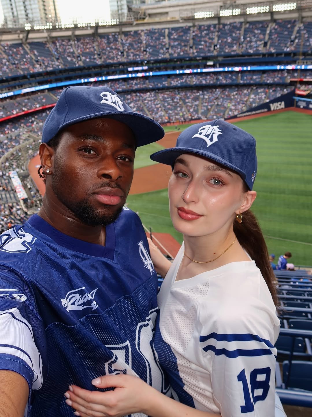Couple selfie in stadium stands wearing team jerseys