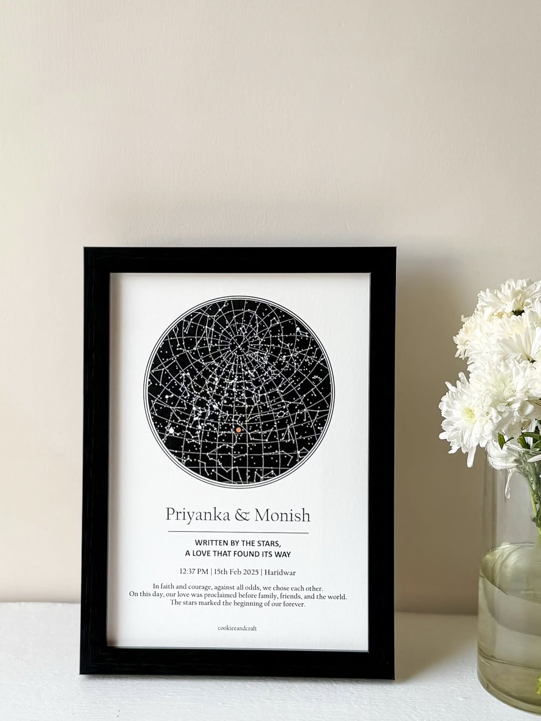 Framed personalized star map print beside flowers