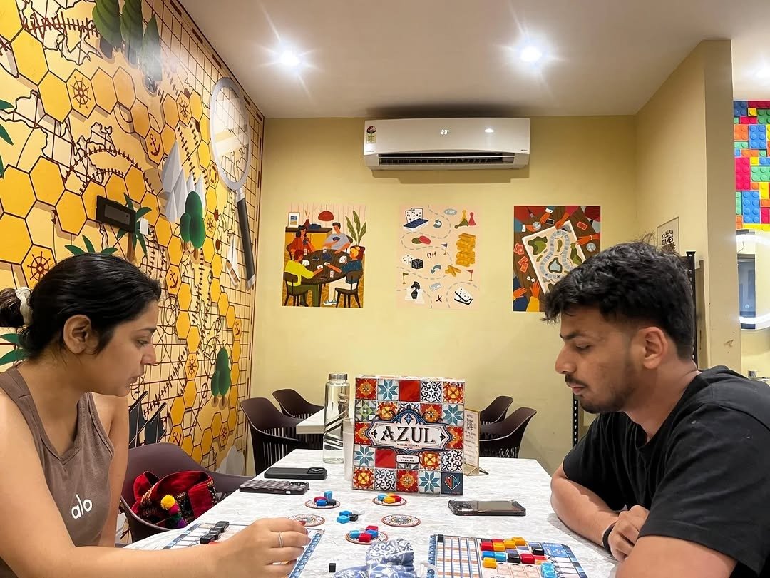 Couple playing Azul board game at a table