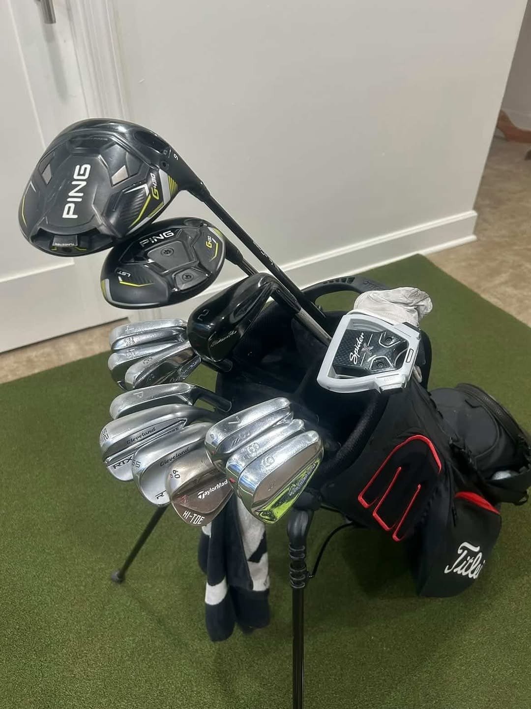 Golf bag full of clubs on green mat