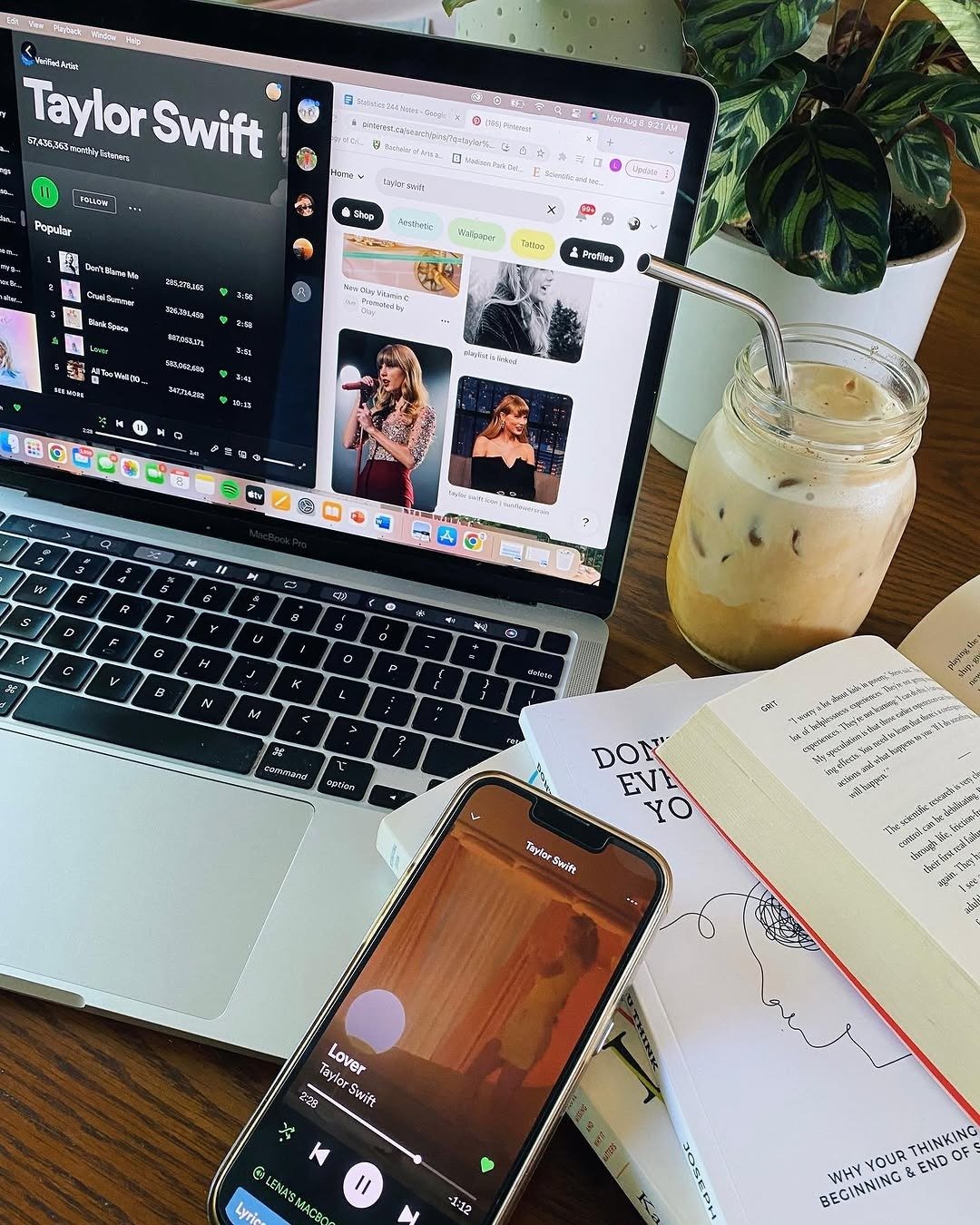 Phone playing music on desk with books and coffee