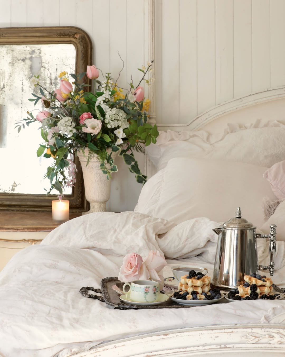 Breakfast tray with waffles, berries and flowers served in a white bed