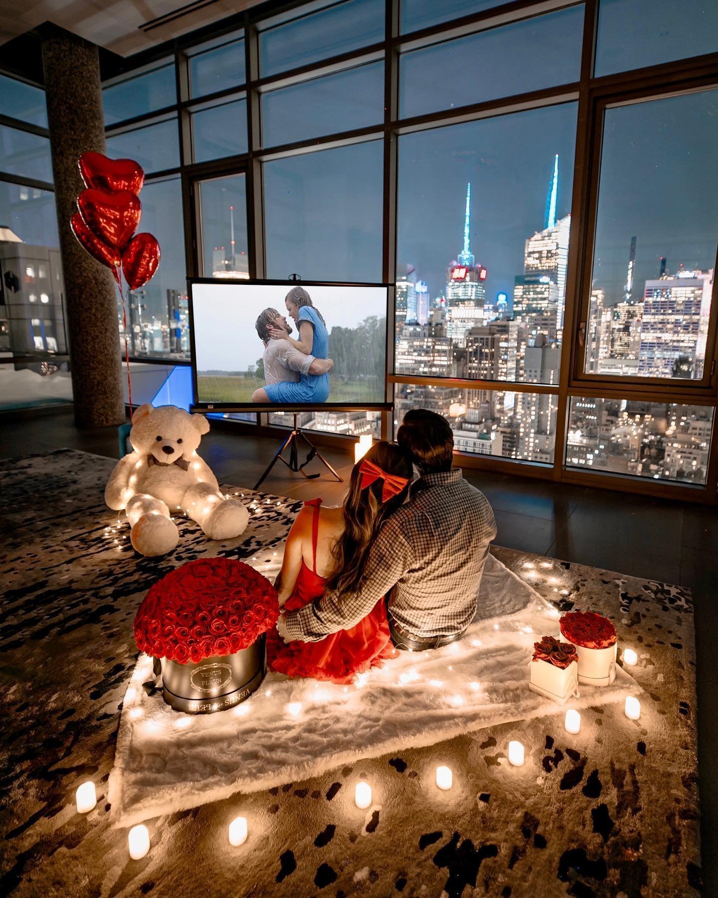 Couple on floor blanket watching a romance film on a projector screen