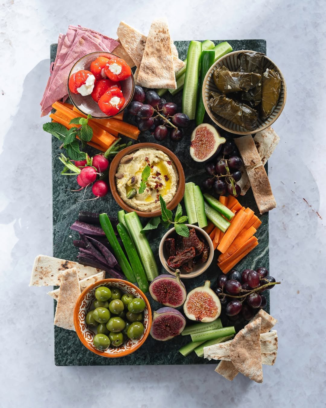 Mediterranean mezze board with hummus, olives, pita and vegetables