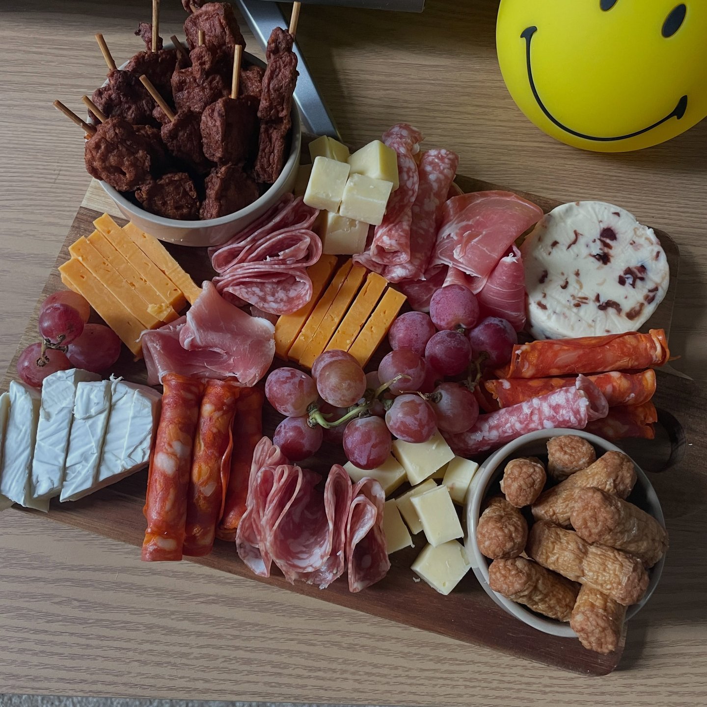 Cheeseboard with assorted cheeses, meats, crackers and fruit