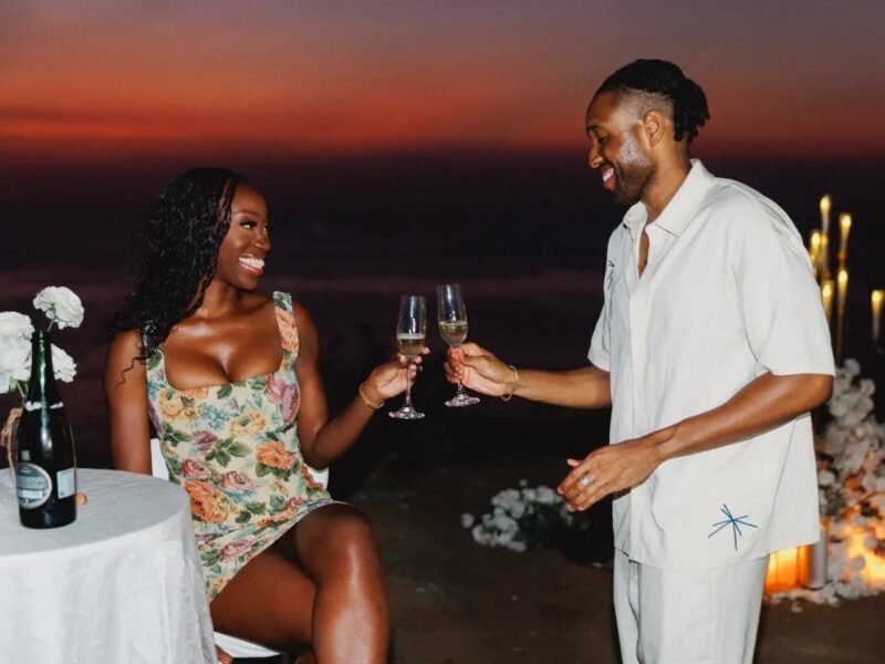 Couple toasting champagne at sunset seaside dinner