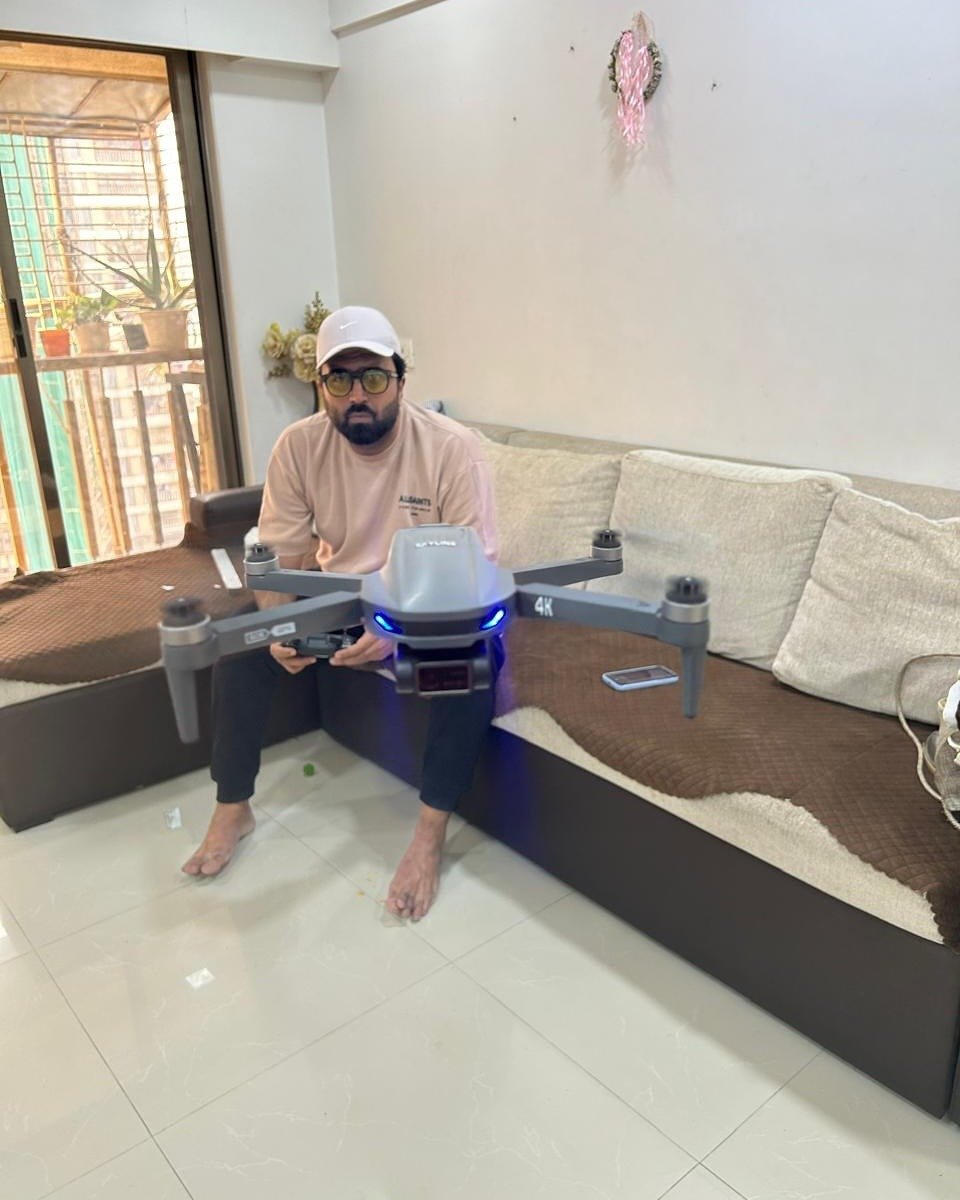 Man with controller and hovering camera drone