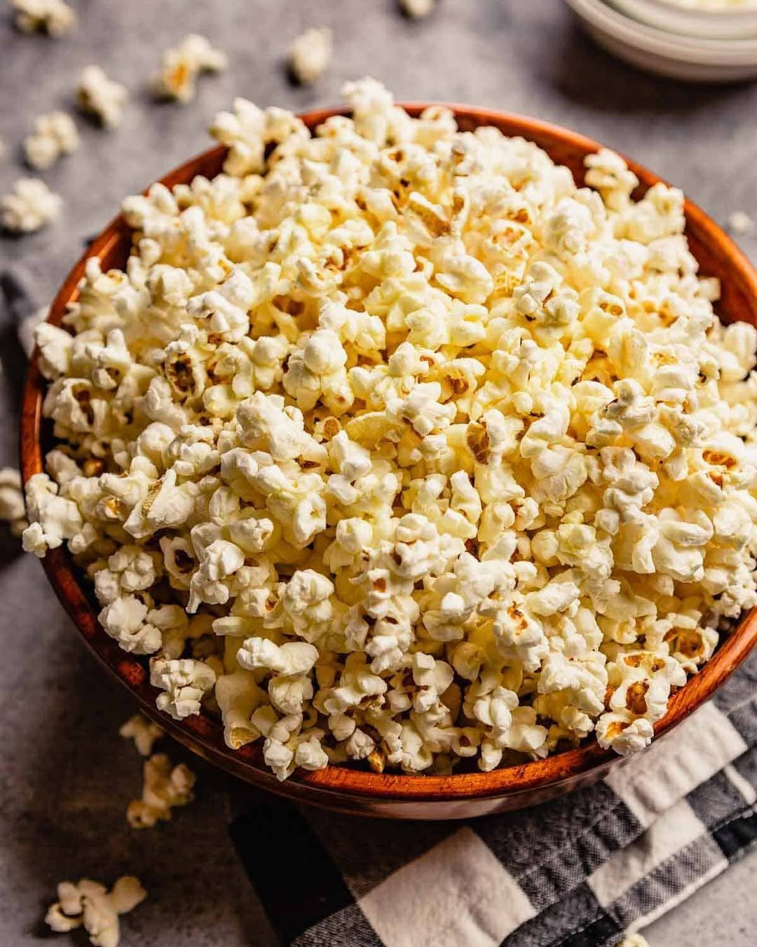 Overhead shot of a wooden bowl of buttery homemade popcorn