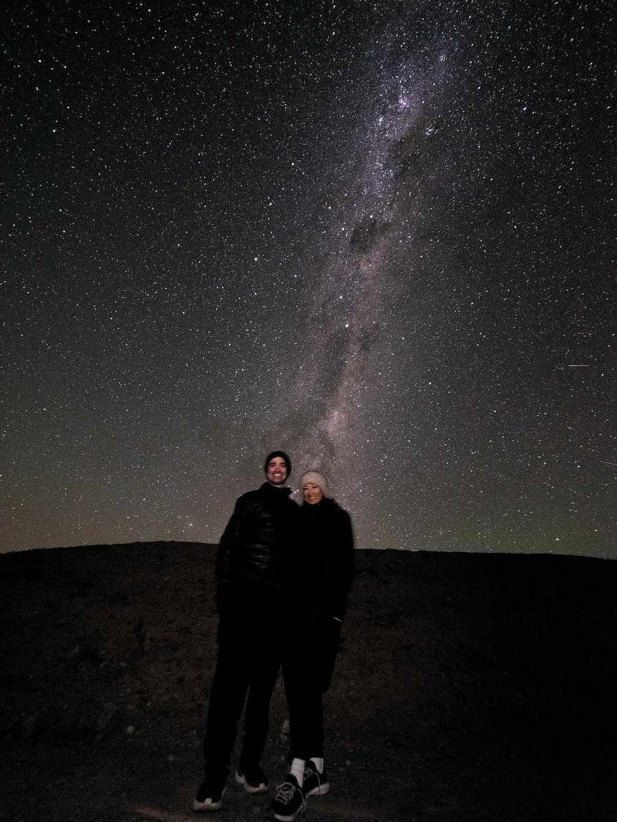 Couple standing under a starry night sky with the Milky Way above, from our outdoor date ideas guide