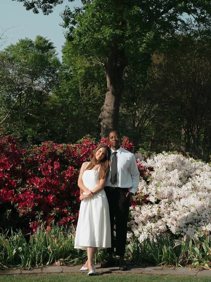 Couple standing among blooming red and white azaleas