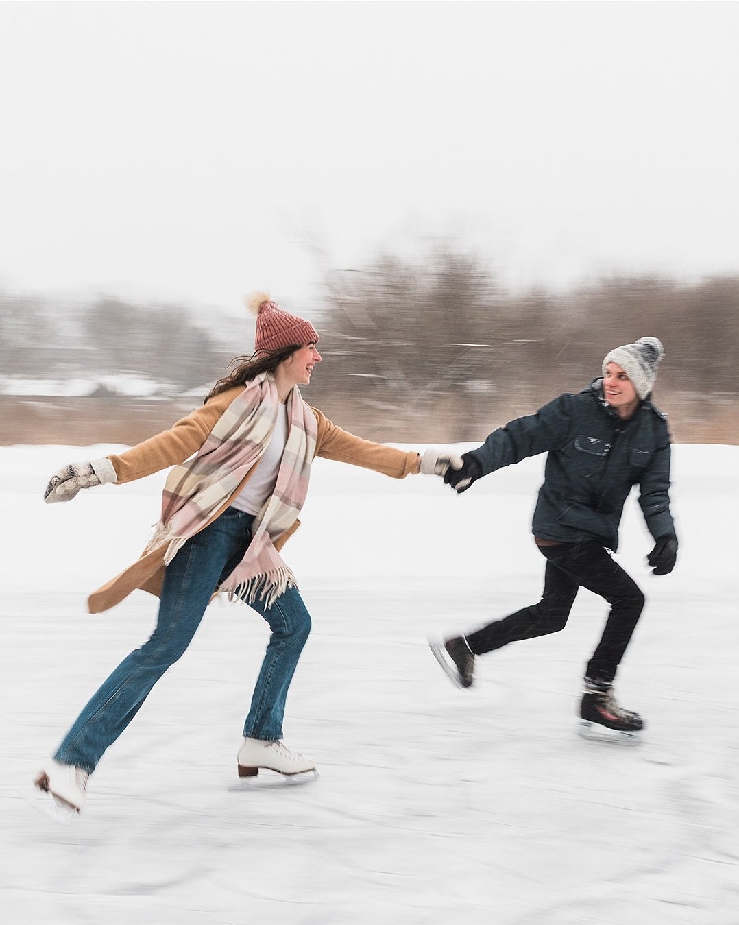 Couple ice skating hand in hand on an outdoor winter rink
