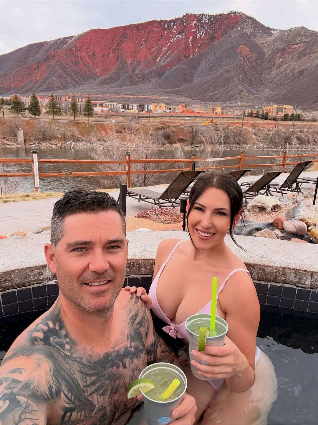 Couple soaking in a hot spring pool with mountain views