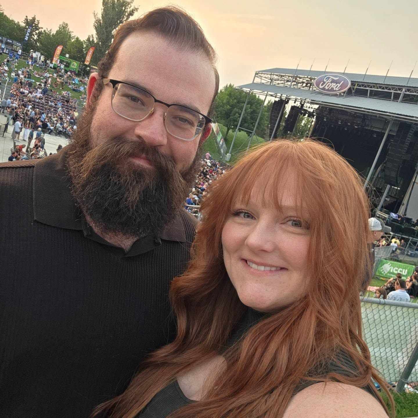 Couple taking a selfie at an outdoor concert venue