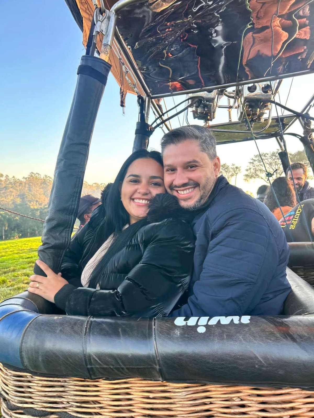 Smiling couple standing in a hot air balloon basket