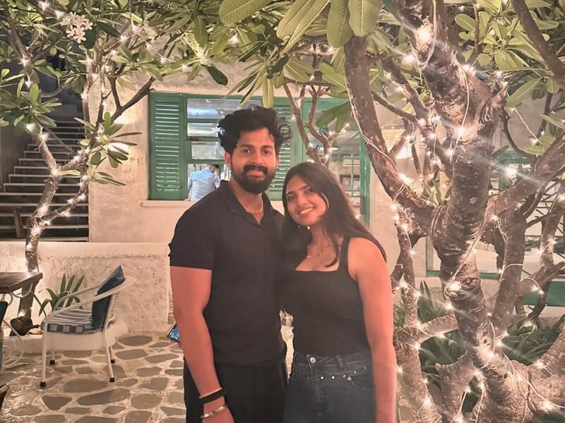 Happy couple sharing a date night in a fairy-lit restaurant courtyard