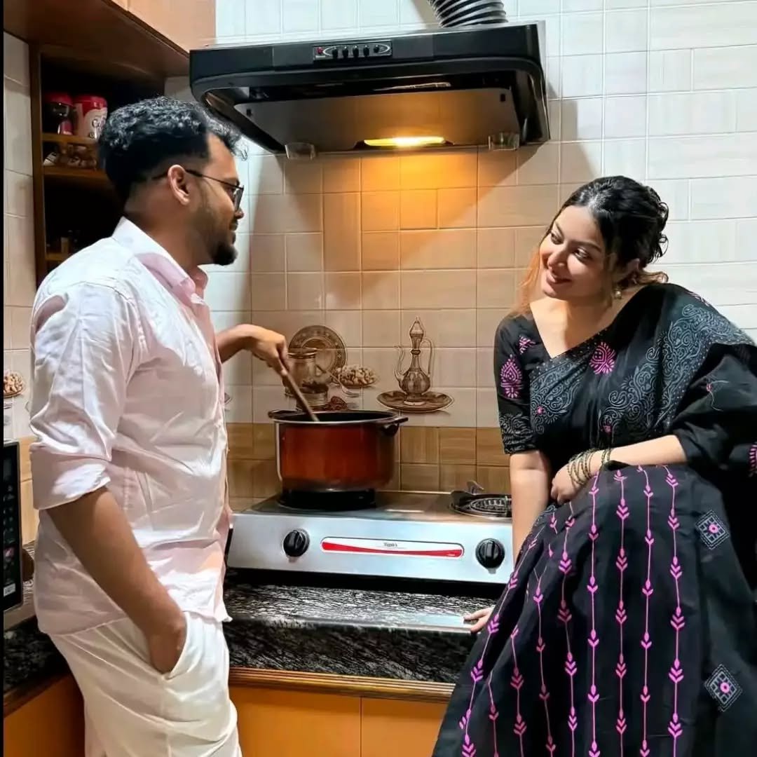 Couple cooking together in the kitchen, man stirring a pot