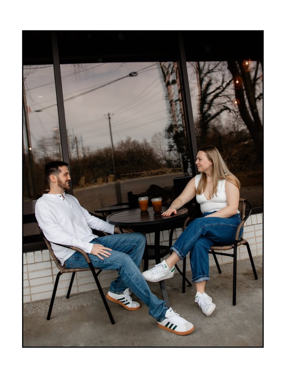 Couple talking across a small table on a porch at dusk
