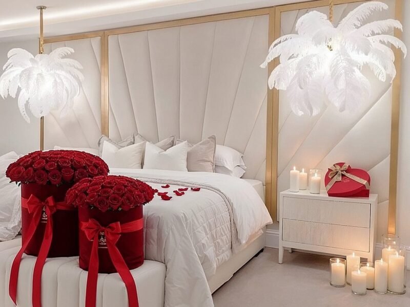 Bedroom decorated with red roses rose petals and lit candles for a surprise date
