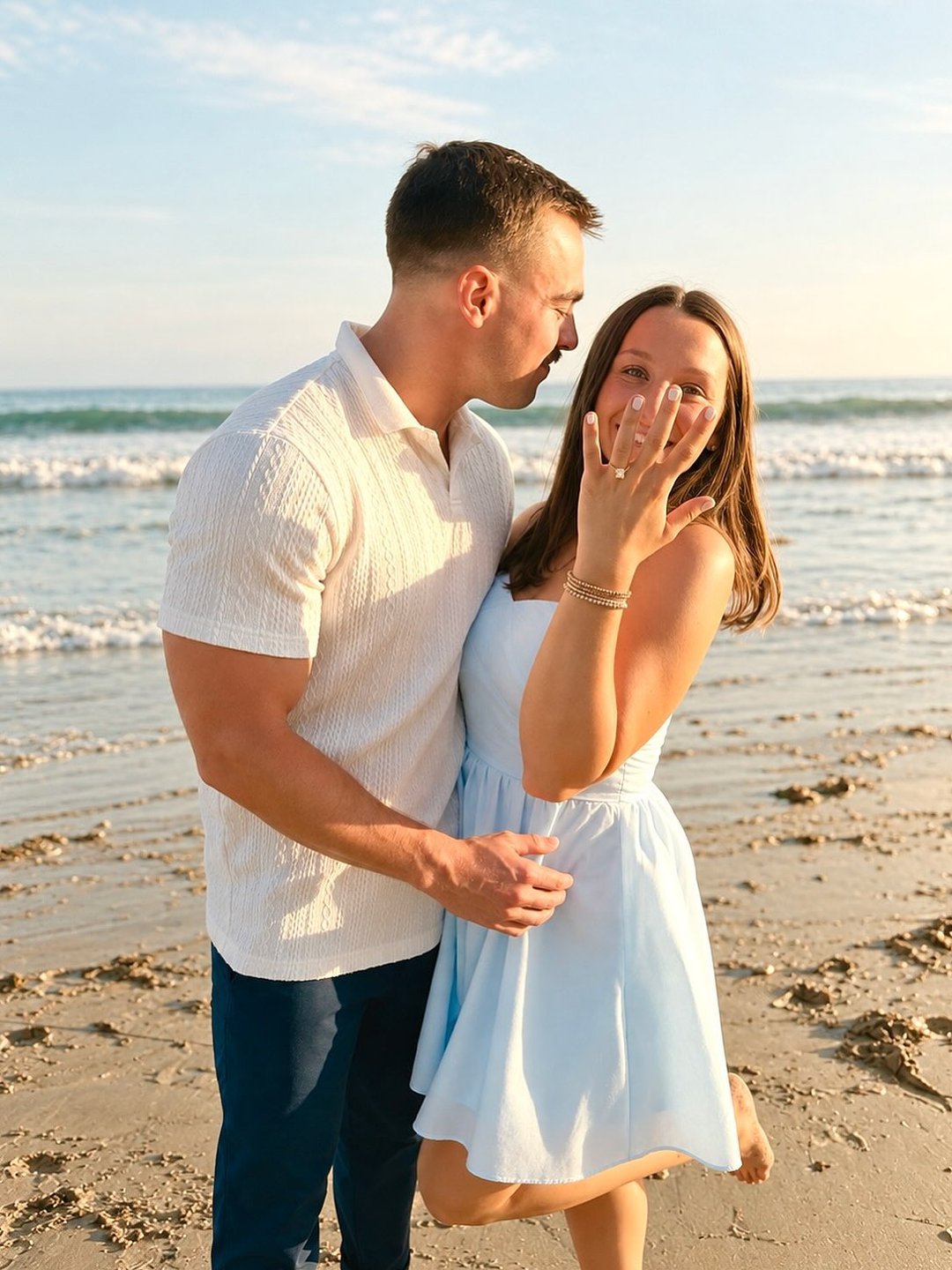 Happy couple embracing on the beach after a surprise proposal