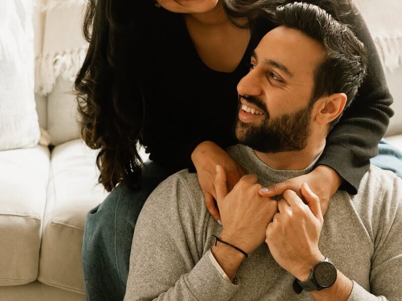 Couple cuddling on couch during cozy date night at home