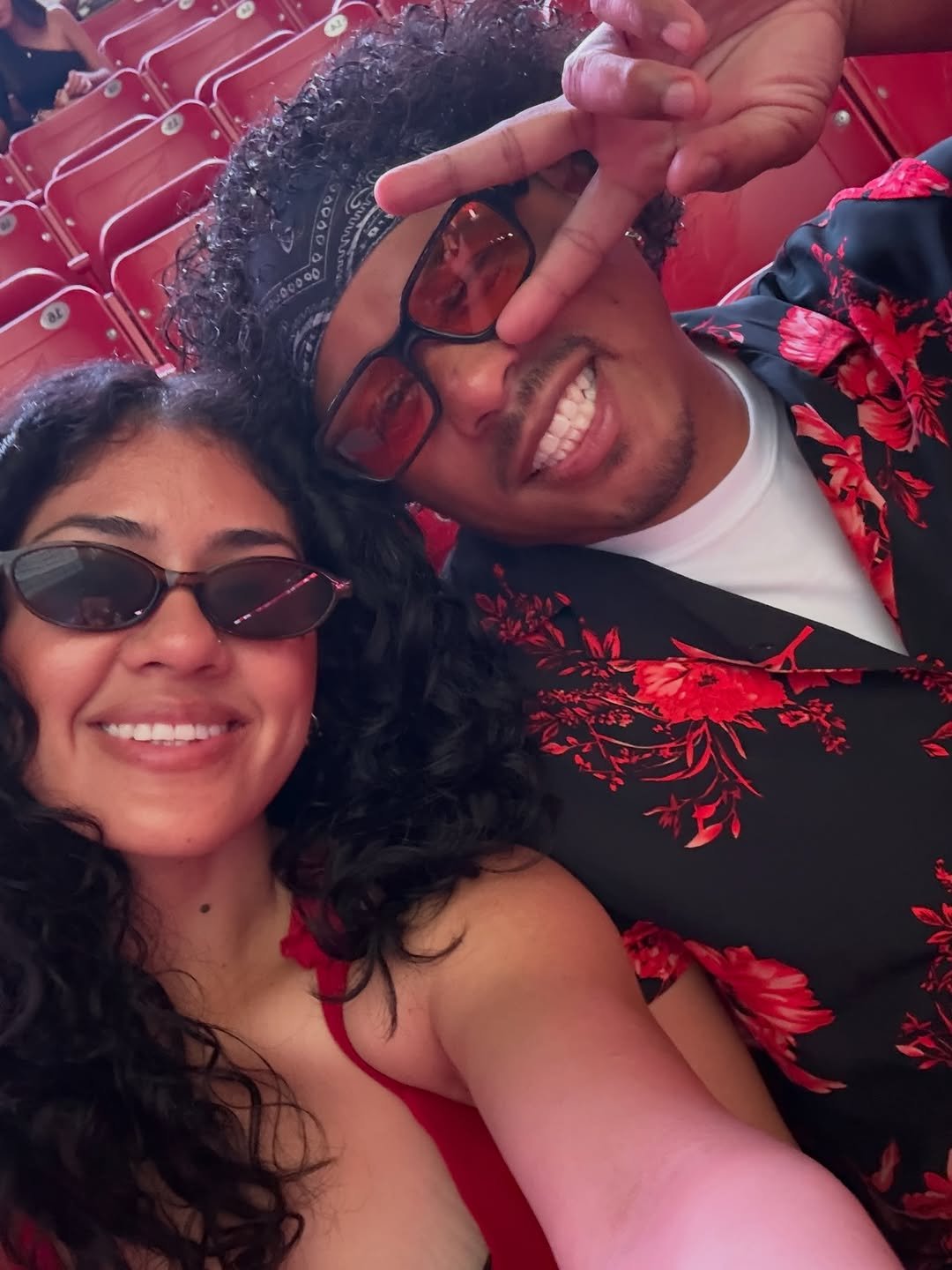 Smiling couple taking selfie in stadium seats at concert