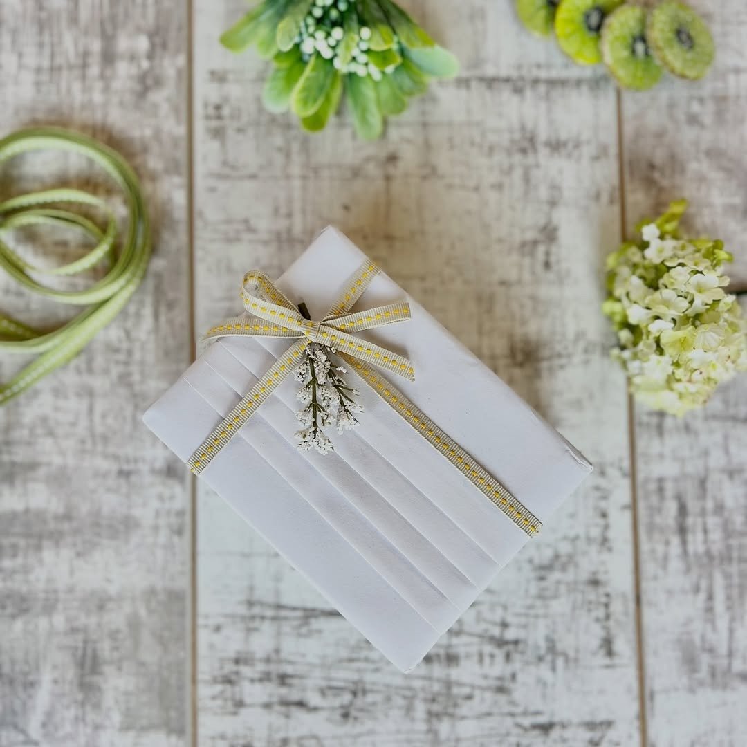 Single small wrapped gift with ribbon on wooden table
