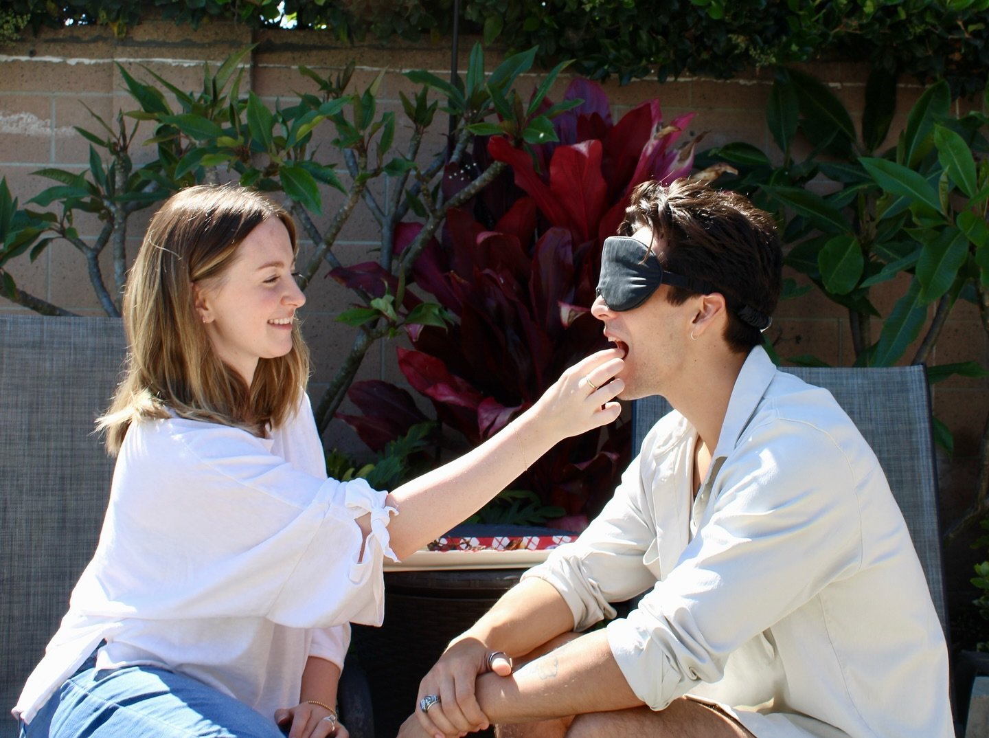 Wife feeding her blindfolded husband during a surprise date challenge