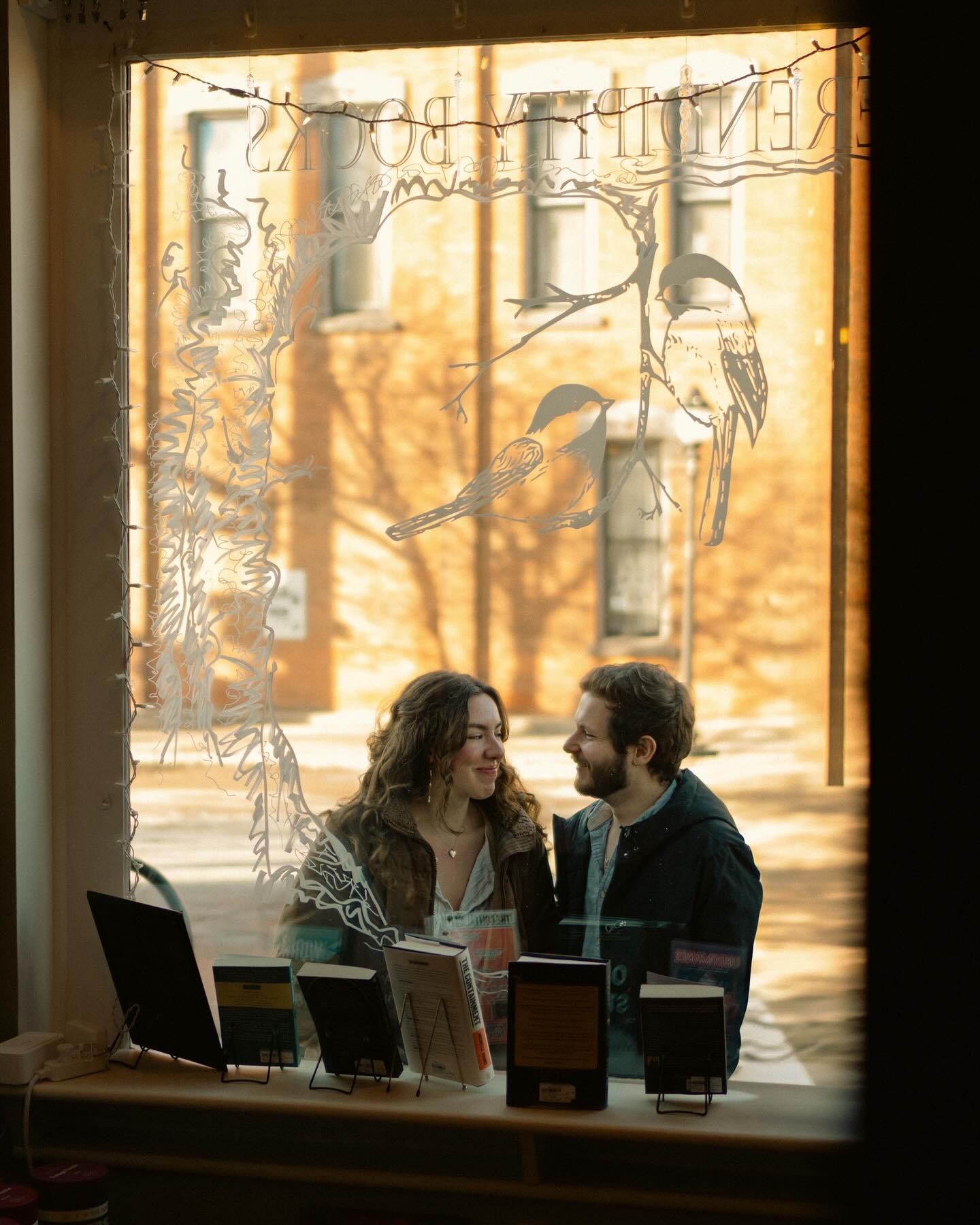 Engaged couple posing inside a bookstore