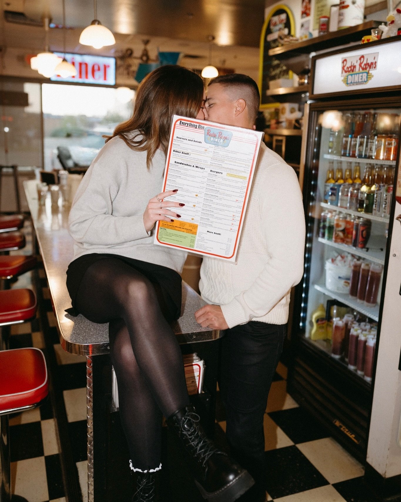 Couple at a 50s diner counter with neon signs