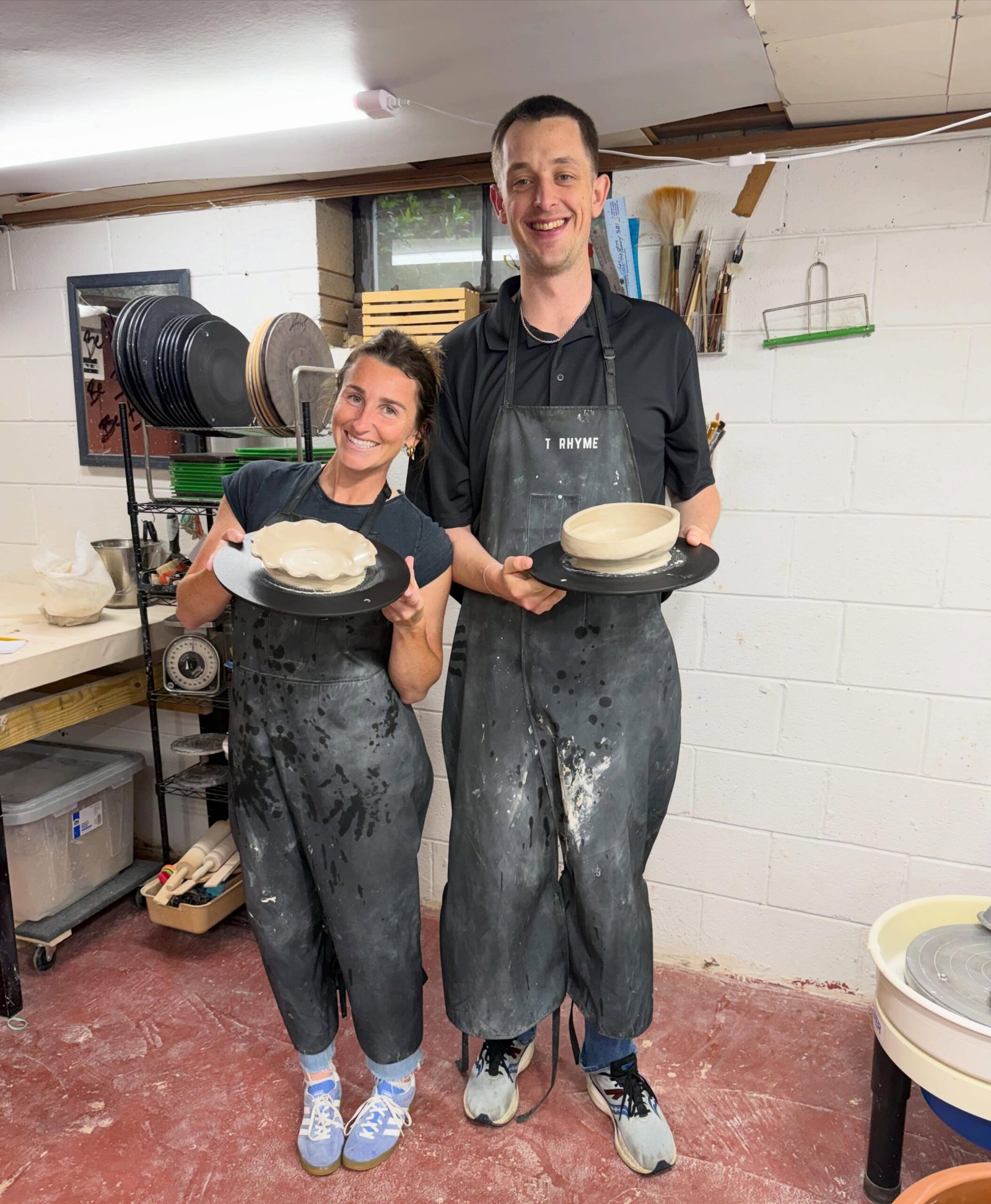Couple at a pottery studio holding their bowls