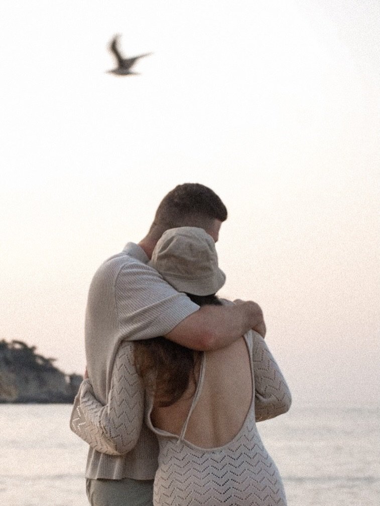 Couple embracing at sunrise by the water