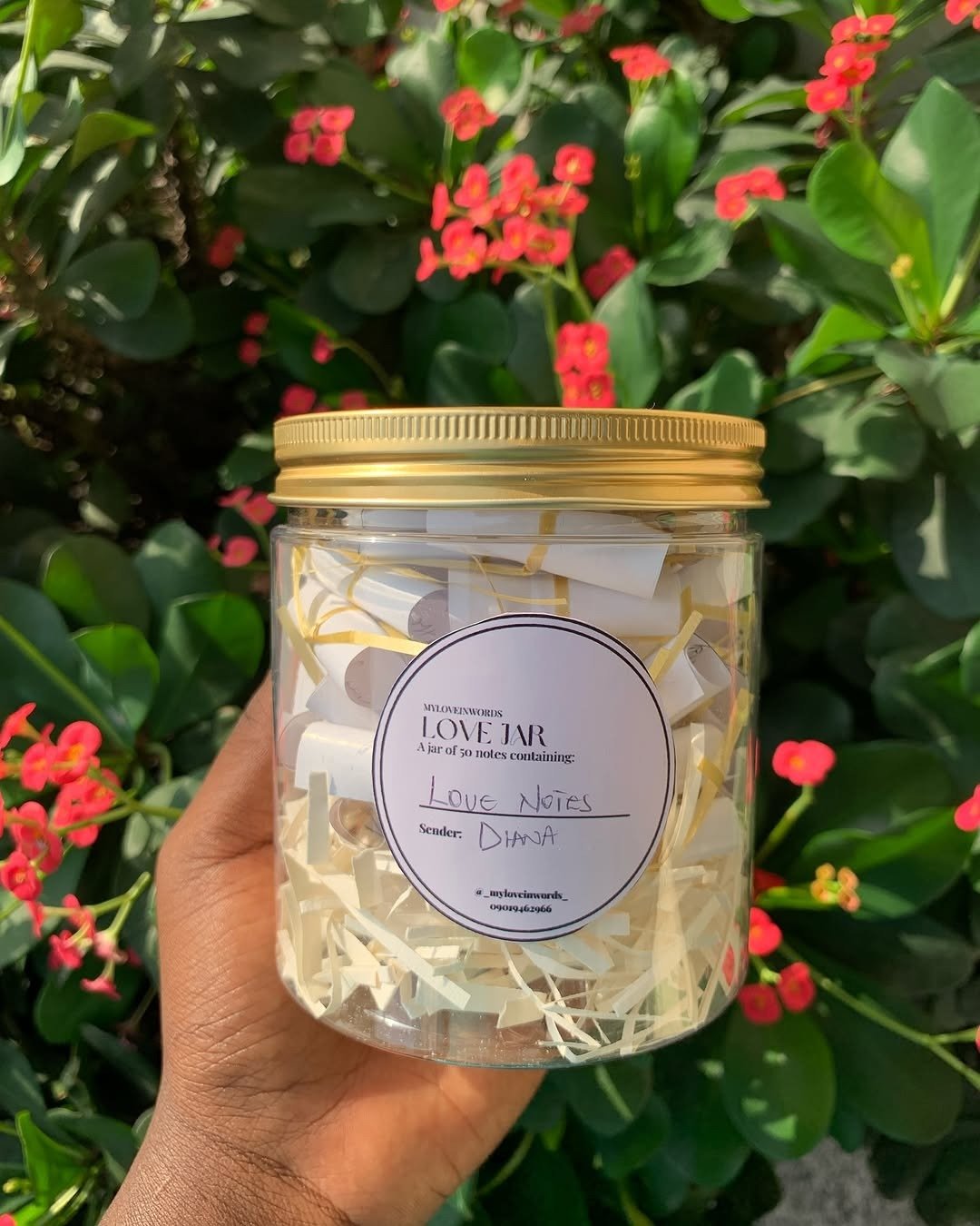 Hand holding jar of folded love notes