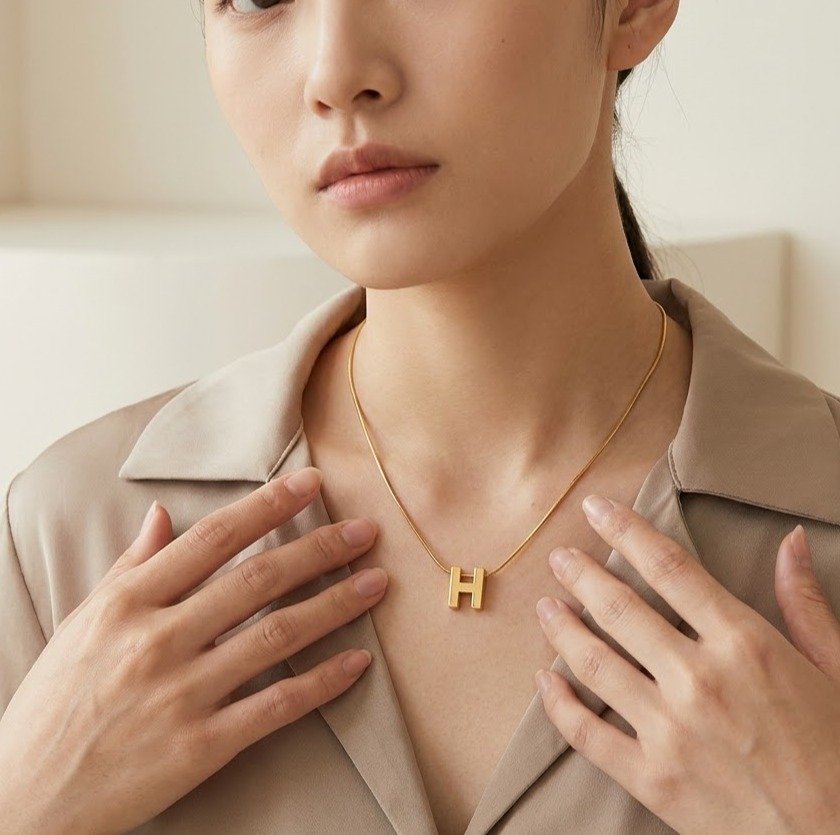 Woman wearing gold initial pendant necklace
