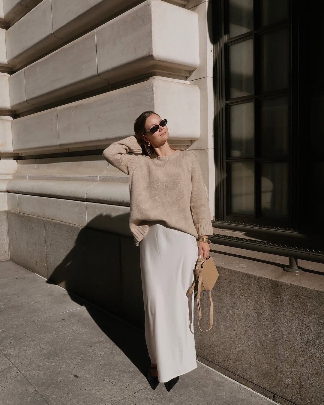 Woman wearing cashmere sweater and satin skirt