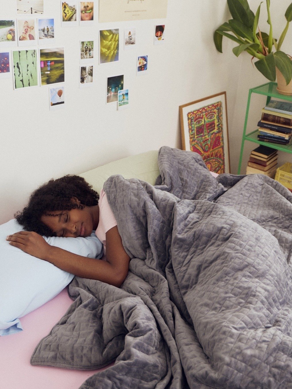 Woman sleeping under grey weighted blanket