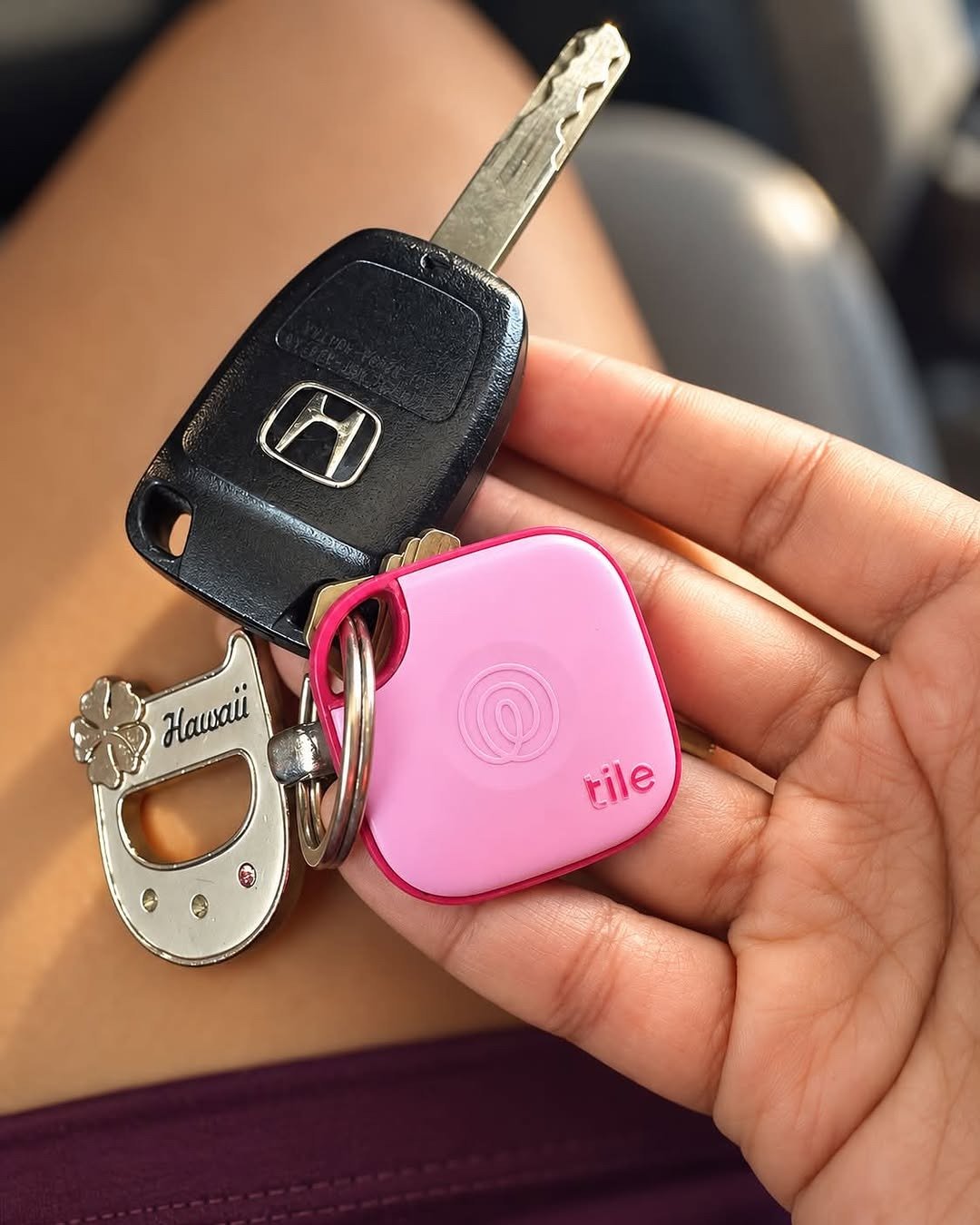 Pink Tile tracker on key ring in hand