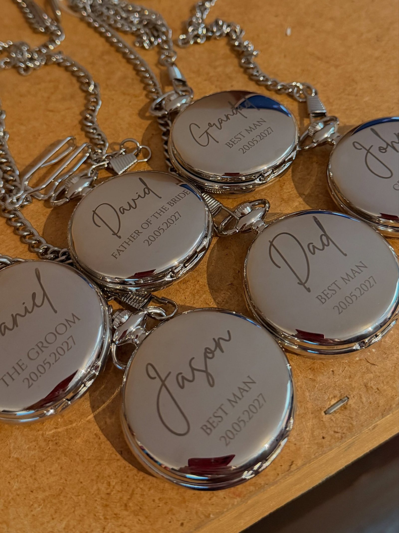 Engraved pocket watches on chains on wood