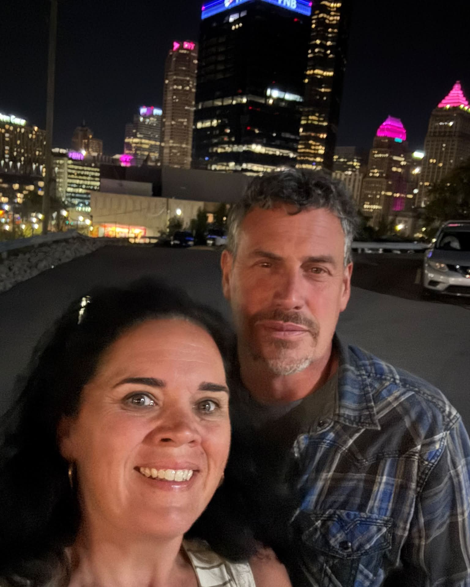 Couple selfie at night concert date with skyline