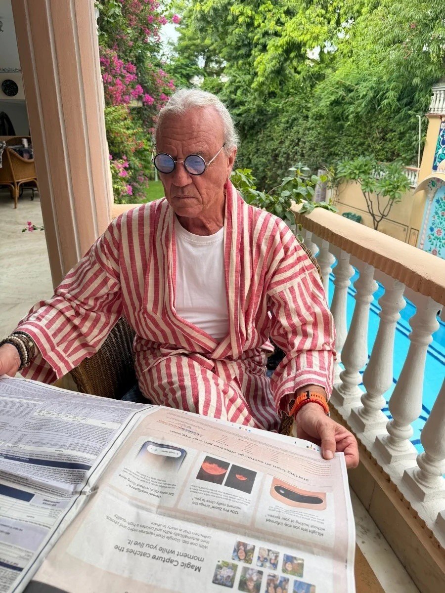 Man in striped cotton robe reading by a pool
