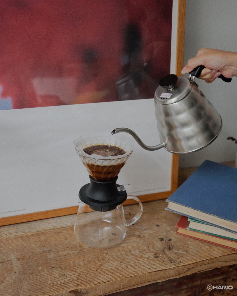 Pouring kettle water into V60 dripper on counter