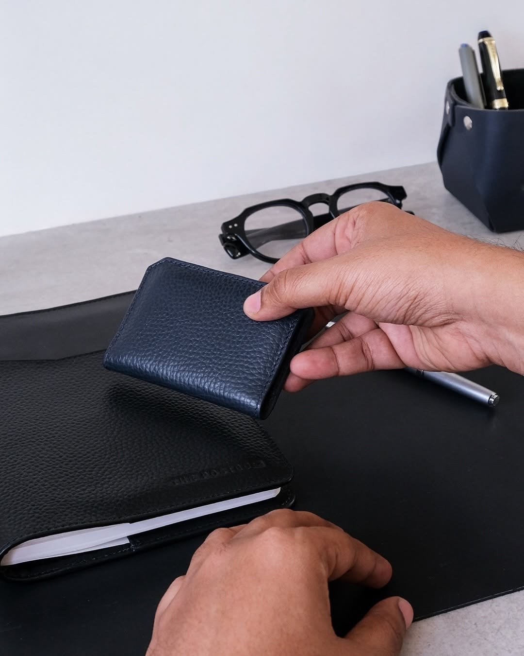 Hand holding slim navy RFID card wallet