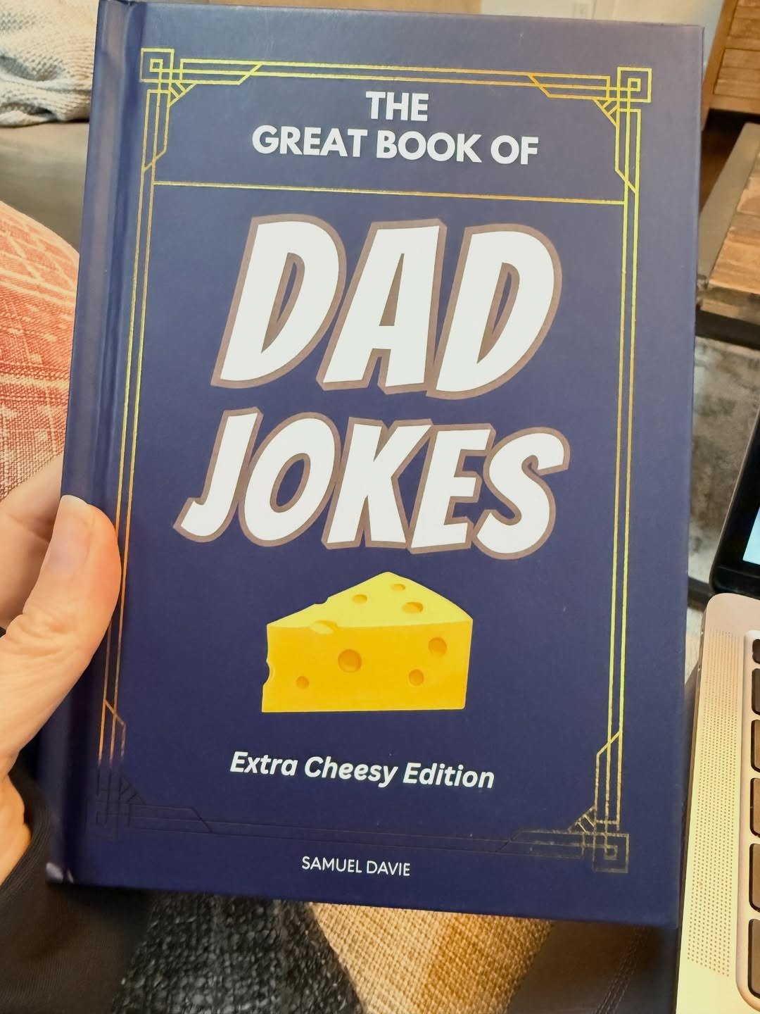 Hand holding The Great Book of Dad Jokes